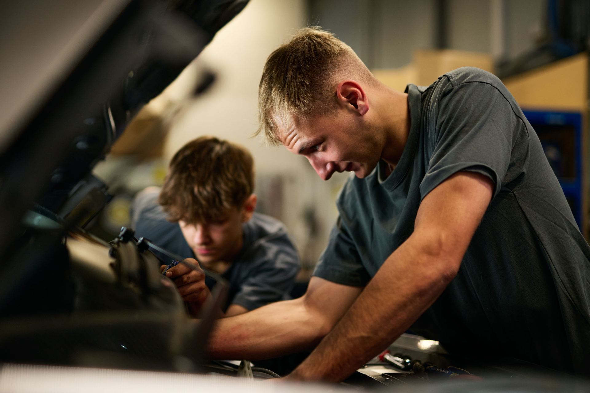 Kfz-Techniker bei der Arbeit im Motorraum